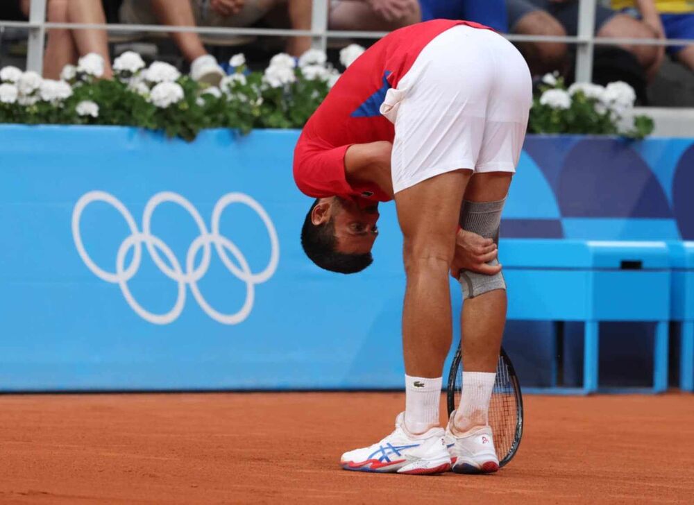 Novak Đoković se drži za koleno na meču protiv Stefanosa Cicipasa na Olimpijskim igrama u Parizu